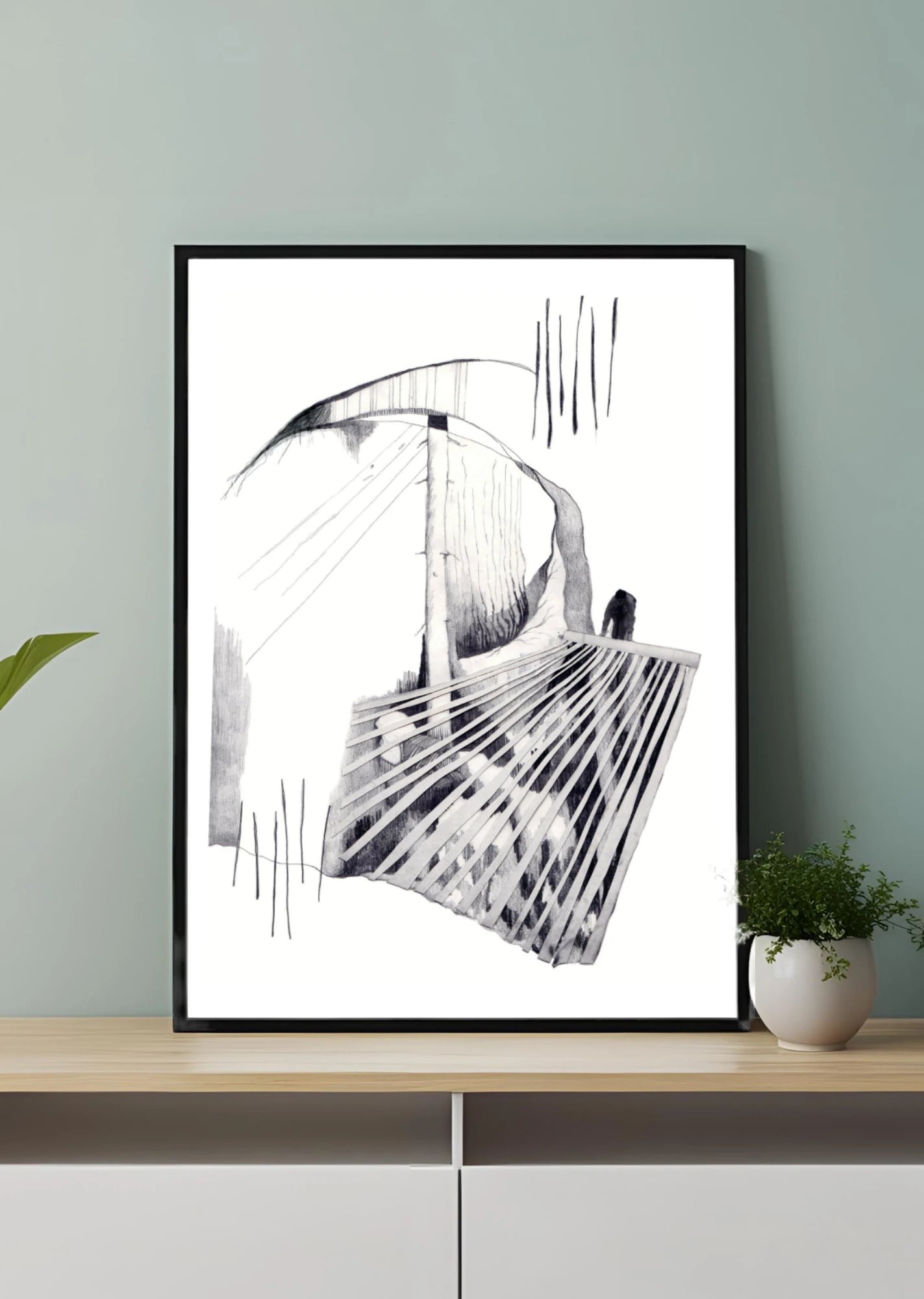 “Minimalistisk svartvit poster i svart ram på träbänk mot mjuk grågrön vägg.