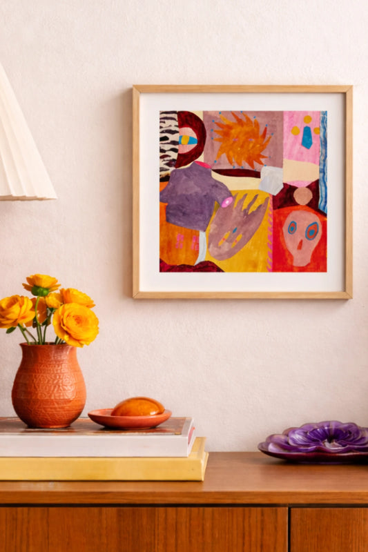 Färgstark abstrakt poster i ekram med orange, rosa och lila toner i varm retroinspirerad interiör.